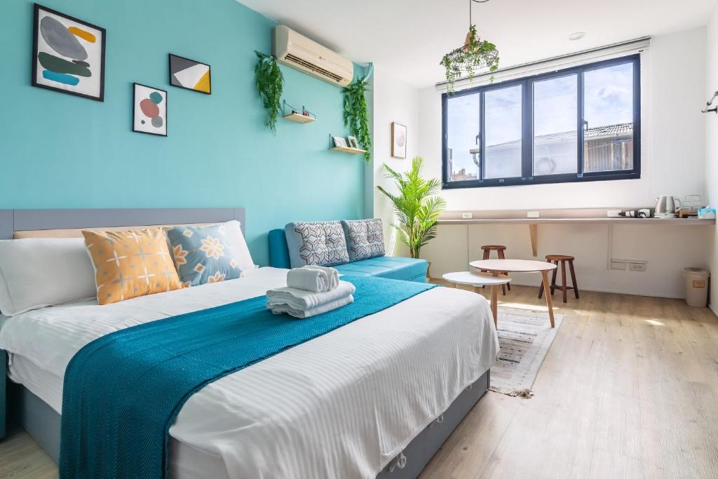台南市にあるSleepier Multi-Minsu Tainanの青い壁のベッドルーム1室(大型ベッド1台付)
