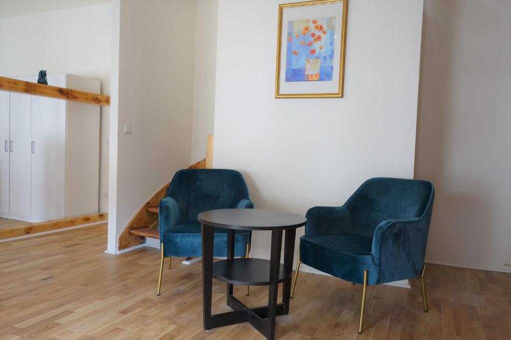 two blue chairs and a table in a room at Nette, geräumige Ferienwohnung in Wuppertal