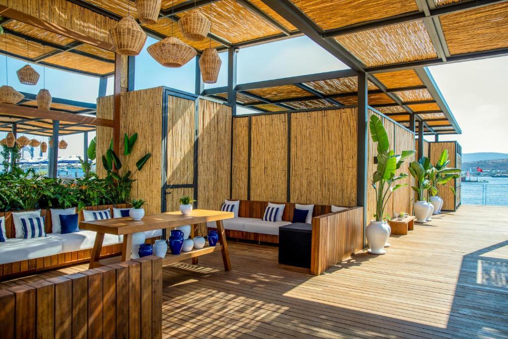 an outdoor patio with a table and chairs and a deck at Kaya Palazzo Resort & Residences Le Chic Bodrum in Bodrum City