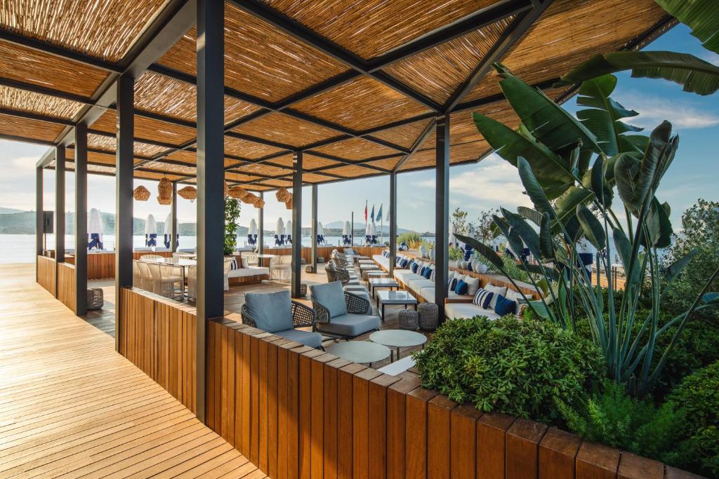 an outdoor patio with chairs and tables on the beach at Kaya Palazzo Resort & Residences Le Chic Bodrum in Bodrum City