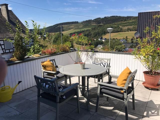 eine Terrasse mit einem Tisch und Stühlen auf einer Terrasse in der Unterkunft Haus Westfeld in Schmallenberg