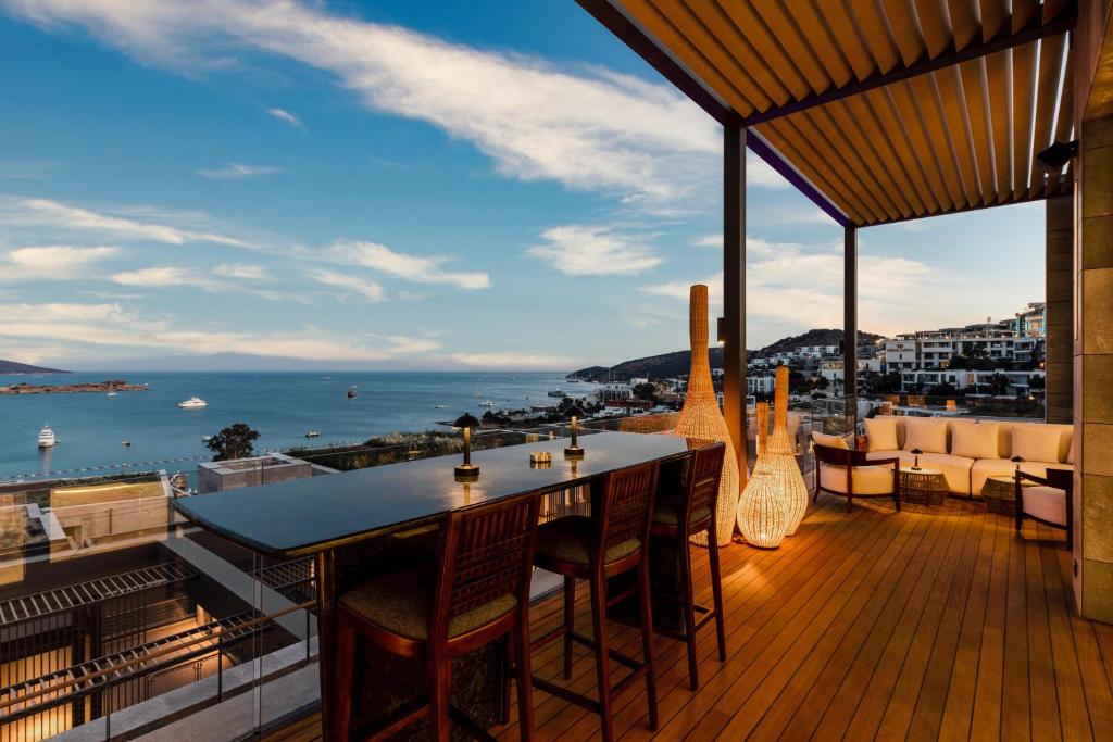 a balcony with a table and chairs and a view of the ocean at Kaya Palazzo Resort & Residences Le Chic Bodrum in Bodrum City