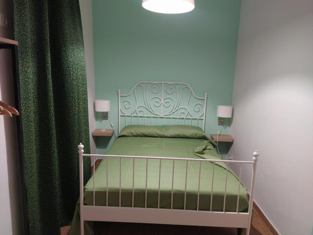 ノートにあるCrocifisso appartamentのベッドルーム1室(緑のカーテン付きのベッド1台付)