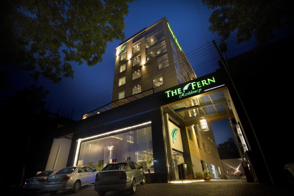钱德加尔芬昌迪加尔酒店的晚上，两辆汽车停在一栋建筑物前
