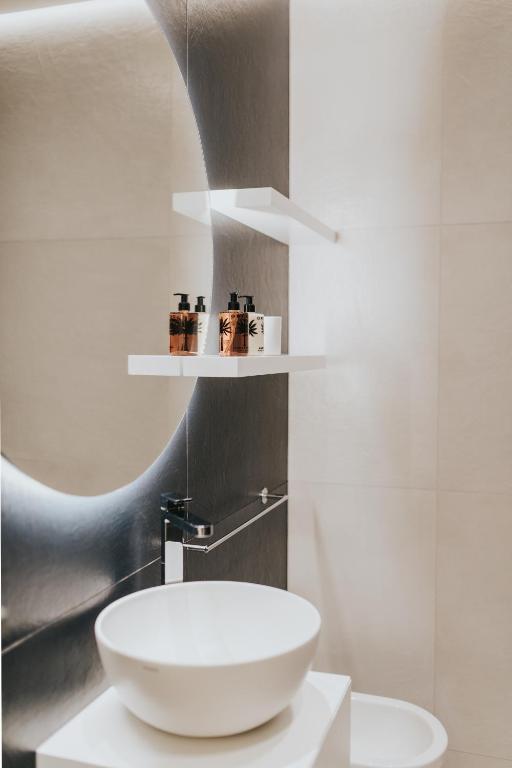 łazienka z białą umywalką i lustrem w obiekcie Bed's Apartments w mieście Soave