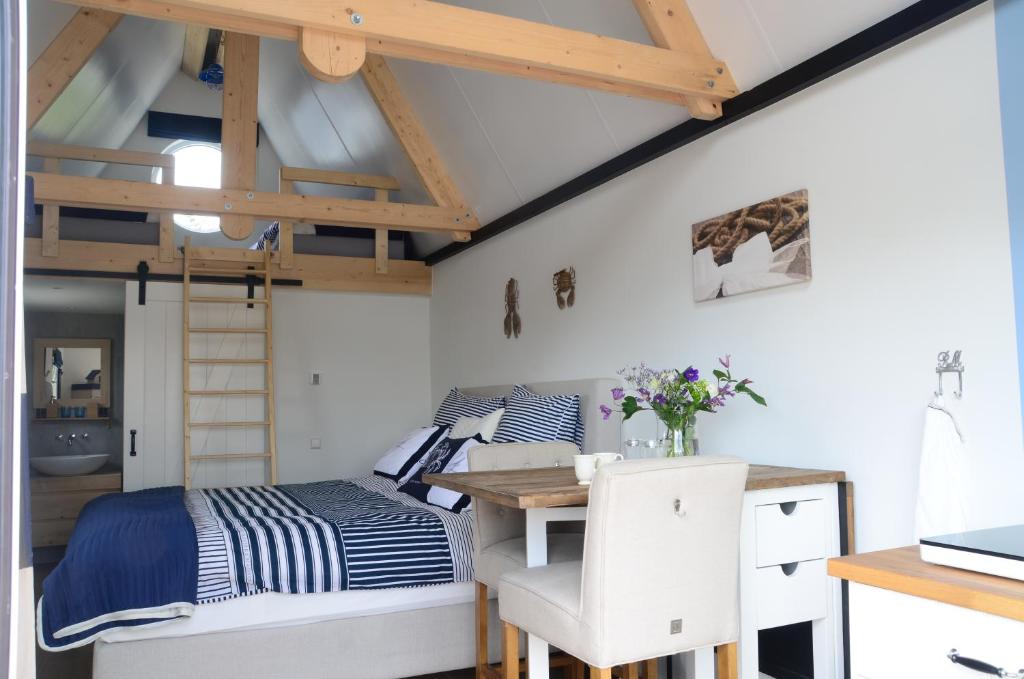 a bedroom with a bed and a desk and a loft bed at Froukje's B&B in Woerdense Verlaat