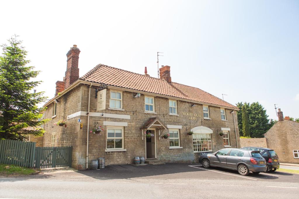 a car parked in front of a brick house at The Woodhouse Arms in Grantham