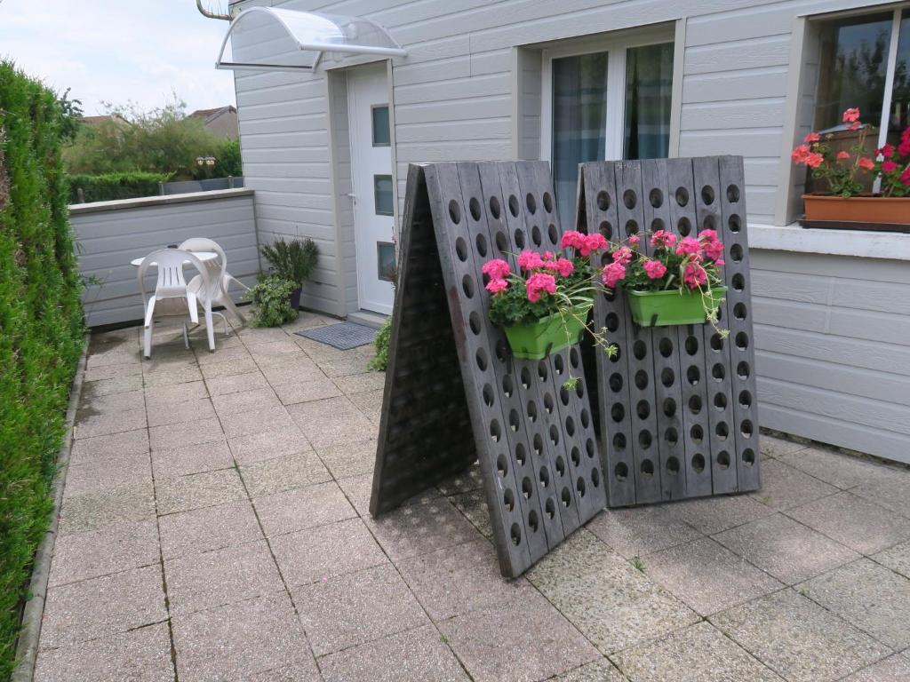 a patio with two potted flowers on a fence at Les Collinades de Chalons in Châlons-en-Champagne