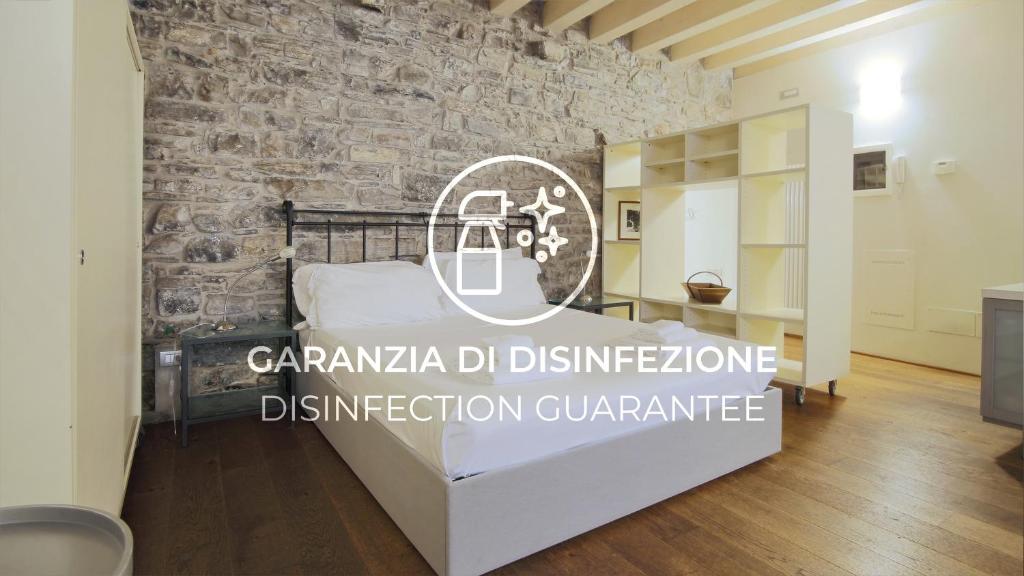 a room with a bed with a stone wall at Italianway - Torno in Torno