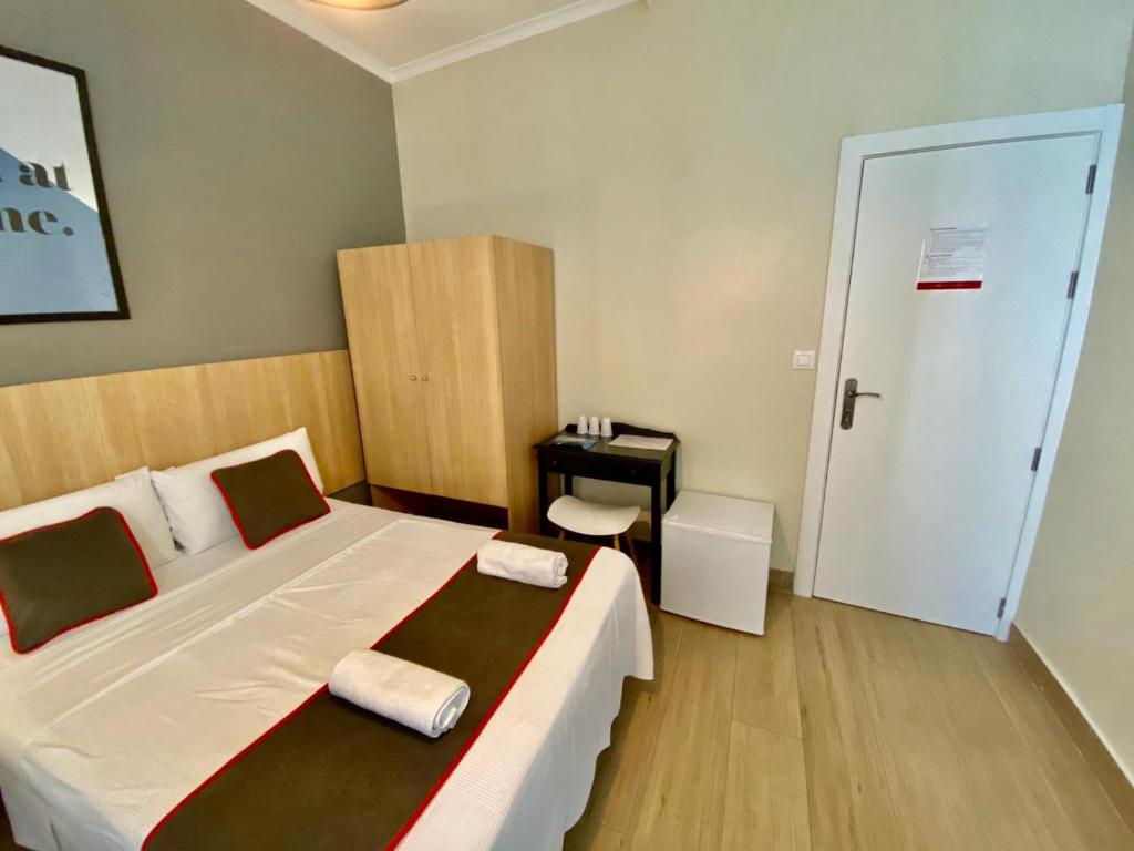 1 dormitorio con cama, escritorio y puerta en CH Las Murallas, en Madrid