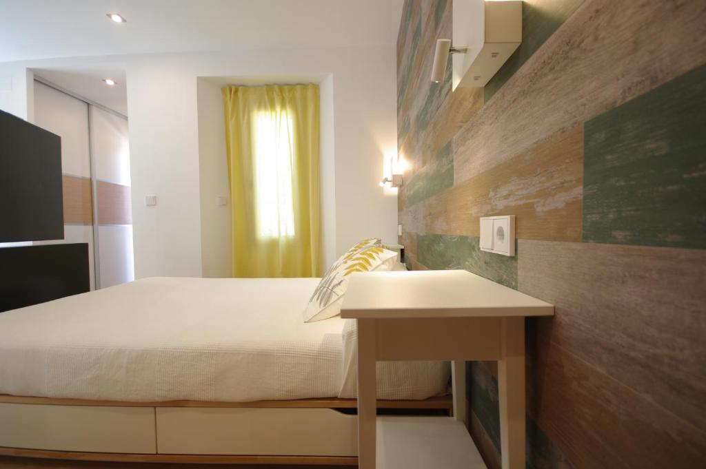 ein kleines Schlafzimmer mit einem Bett und einem Tisch in der Unterkunft La casita de Sofi in Facinas