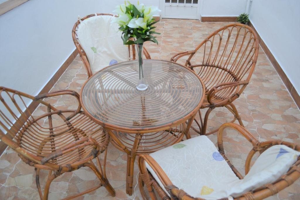 stół z krzesłami i wazon z kwiatami w obiekcie Genius Apartments w Alicante