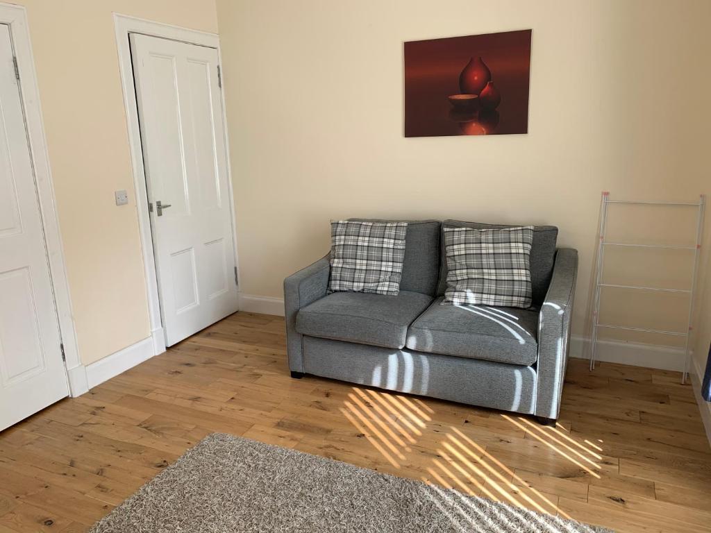 a living room with a grey couch and a rug at 105 Nelson Street in Largs