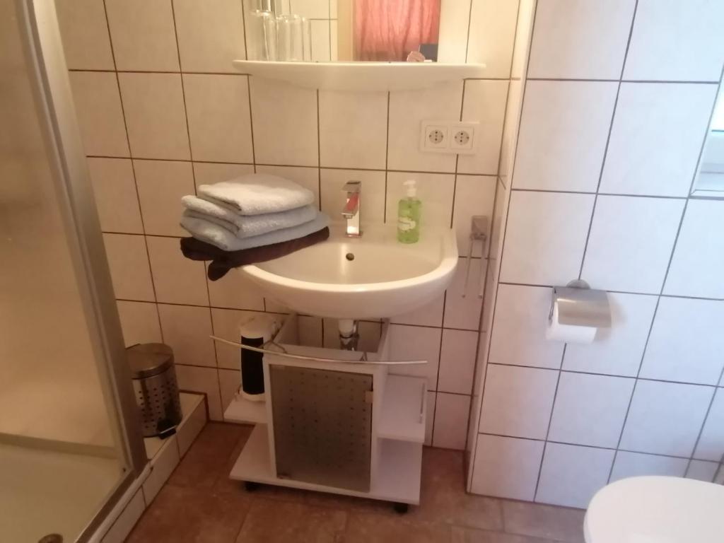 Apartment in Stauseenähe في Rainau: حمام مع حوض عليه مناشف