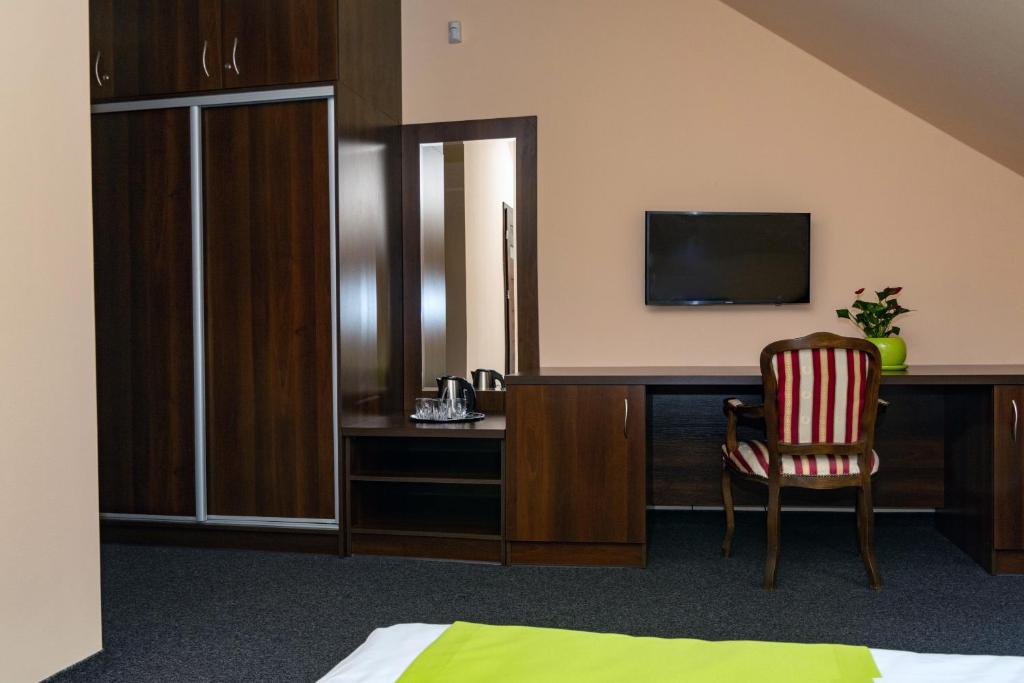 Pokój hotelowy z biurkiem, telewizorem i krzesłem w obiekcie Pokoje Gościnne z łazienkami w Niepołomicach