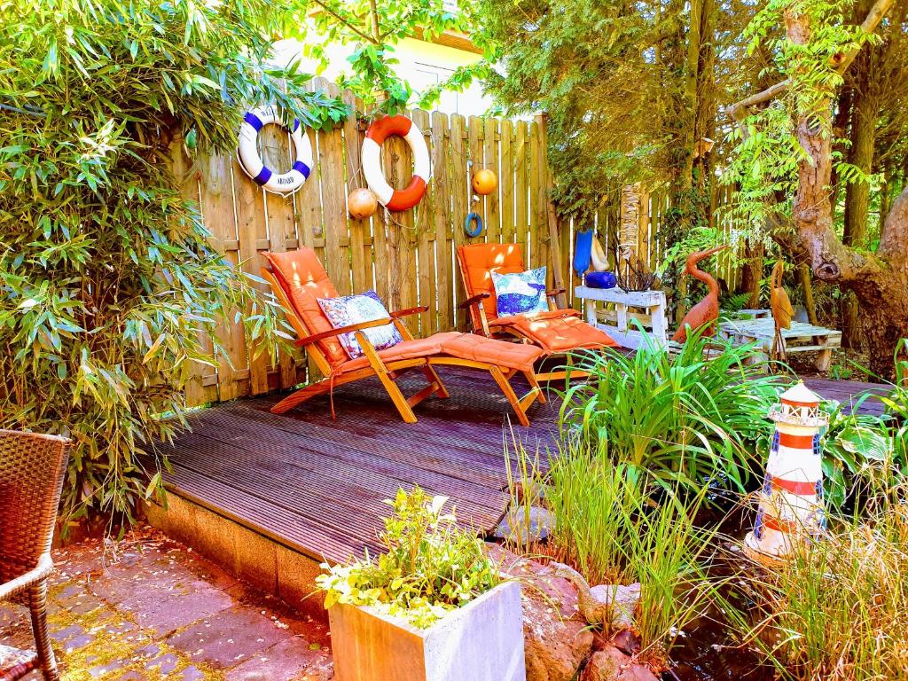 una terraza de madera con sillas y una valla en Ferienwohnung im Garten Eden en Grünberg