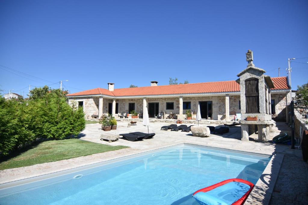 uma grande piscina em frente a uma casa em Quinchoso dos Bentos em Vila Pouca de Aguiar