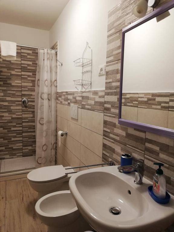 łazienka z umywalką, toaletą i lustrem w obiekcie CASA ANTONIETTA w mieście Bivigliano