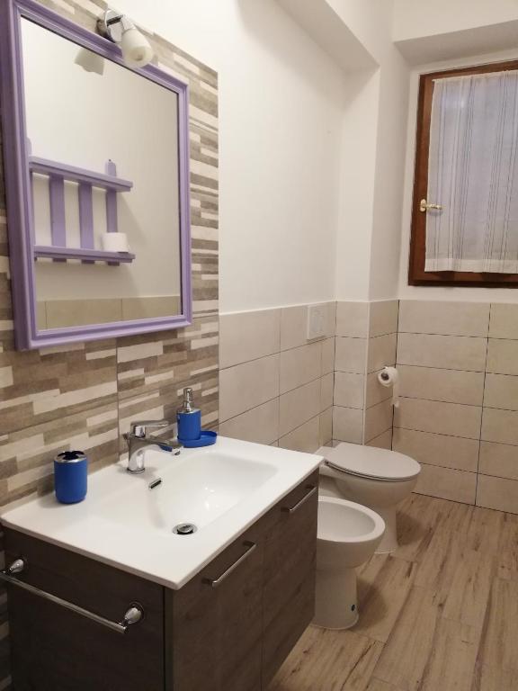 łazienka z umywalką, toaletą i lustrem w obiekcie CASA ANTONIETTA w mieście Bivigliano