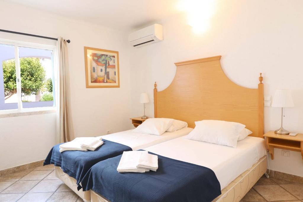 a bedroom with two beds and a window at Windmill Hill in Albufeira
