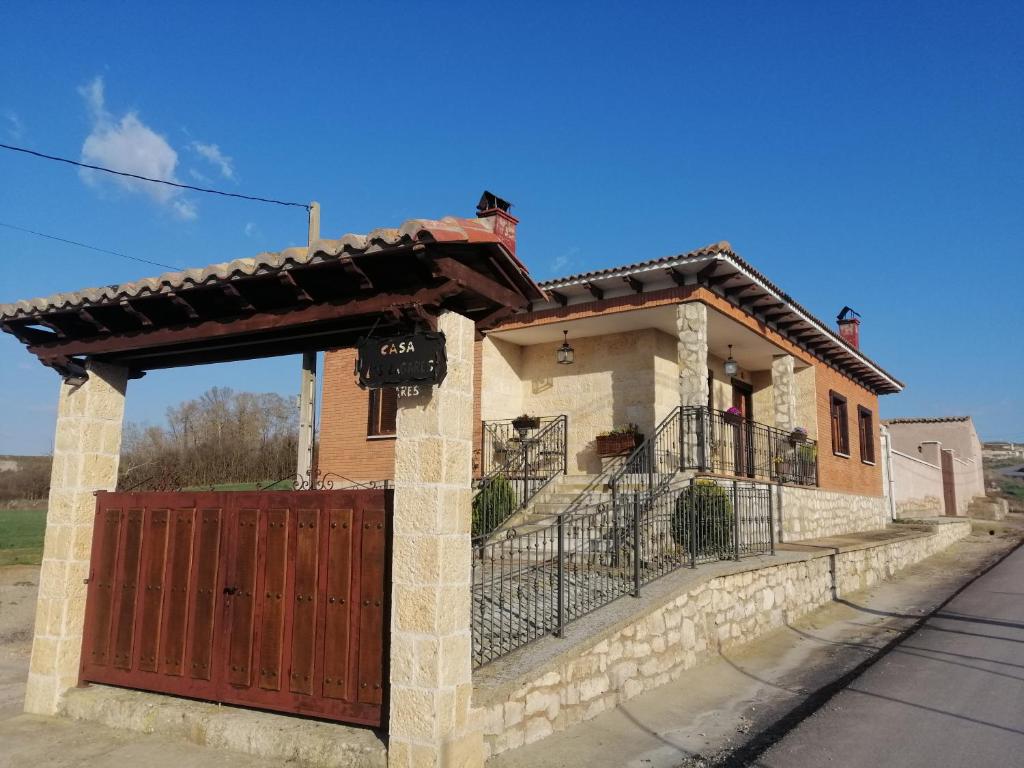 a house with a wooden gate and a fence at Casa Los Lagares in Peral de Arlanza