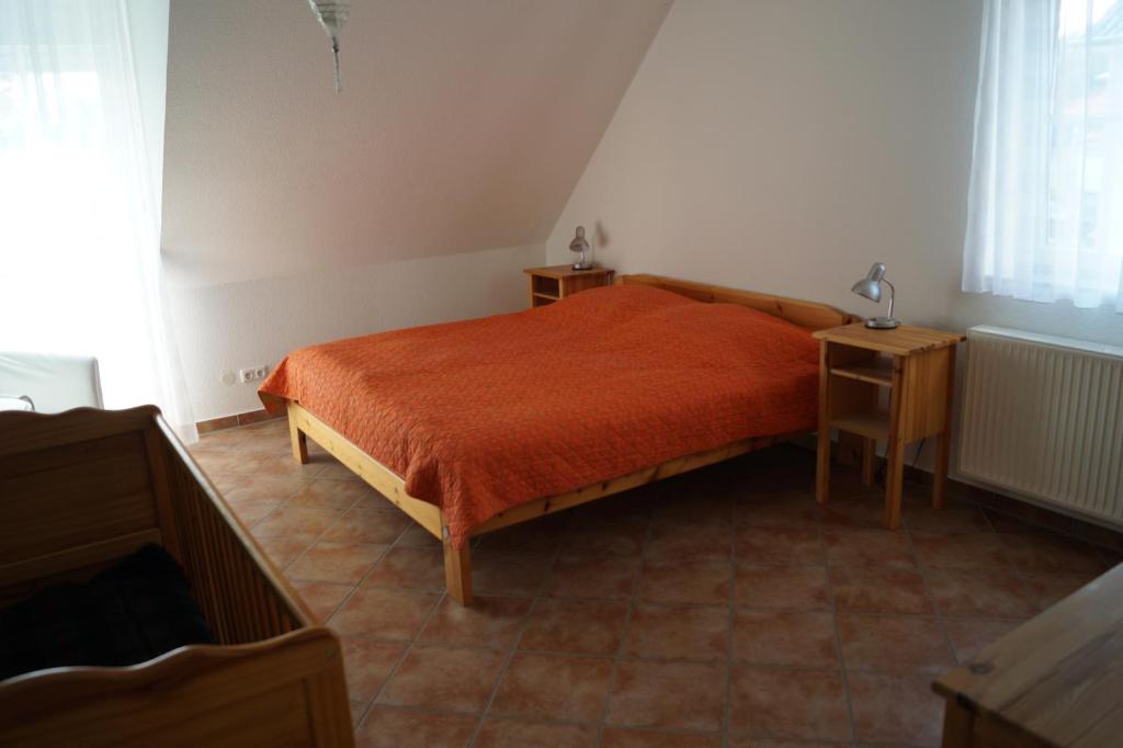 una camera con un letto e una coperta arancione di Bontemps Apartment a Timmendorfer Strand