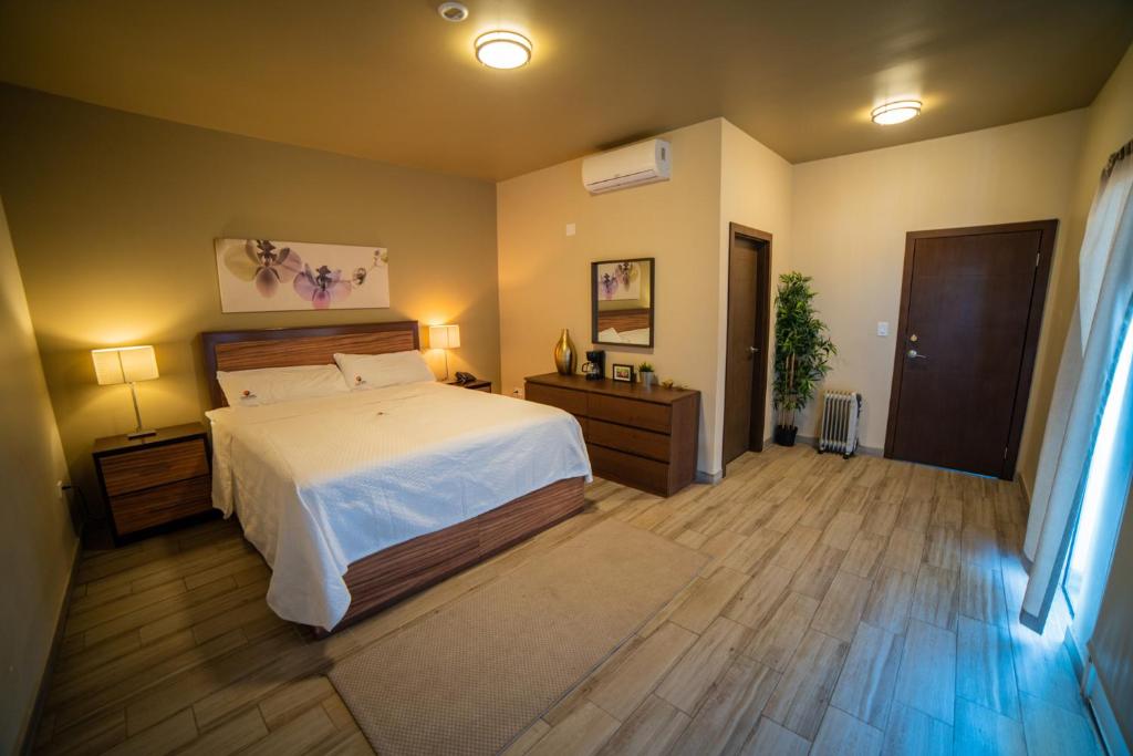 California Comfort & Suites في Los Algodones: غرفة نوم بسرير ابيض وارضية خشبية