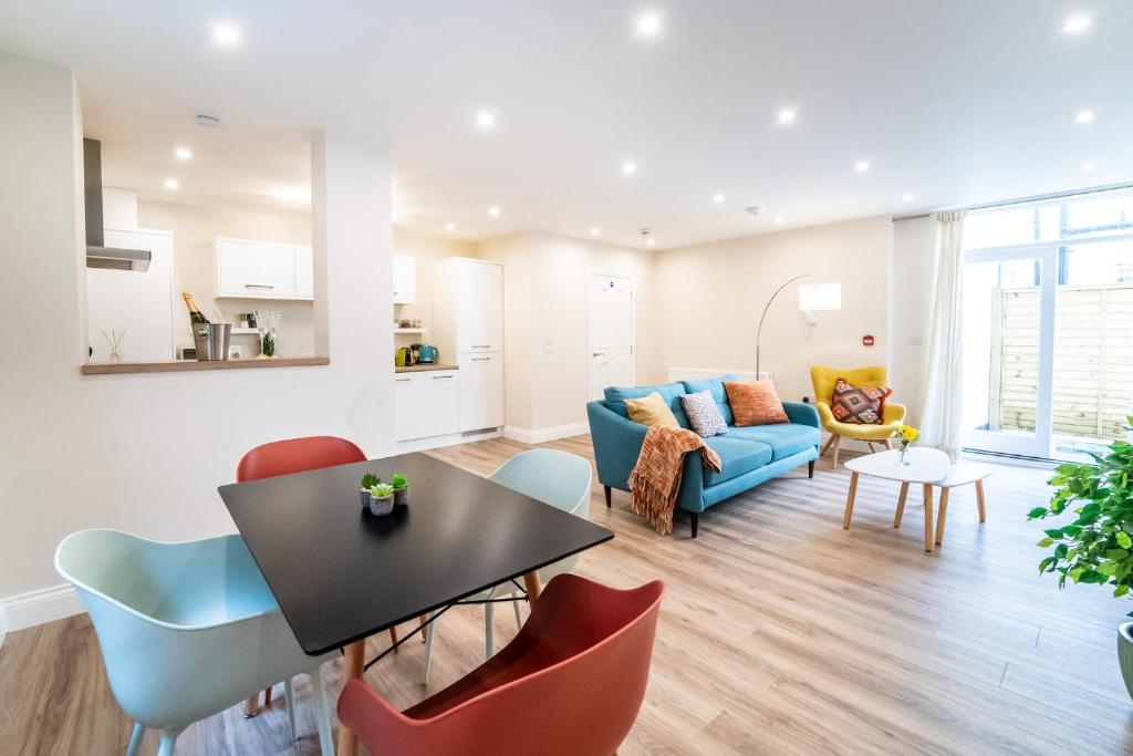 uma sala de estar com um sofá azul e cadeiras em South Quay Apartment em Great Yarmouth