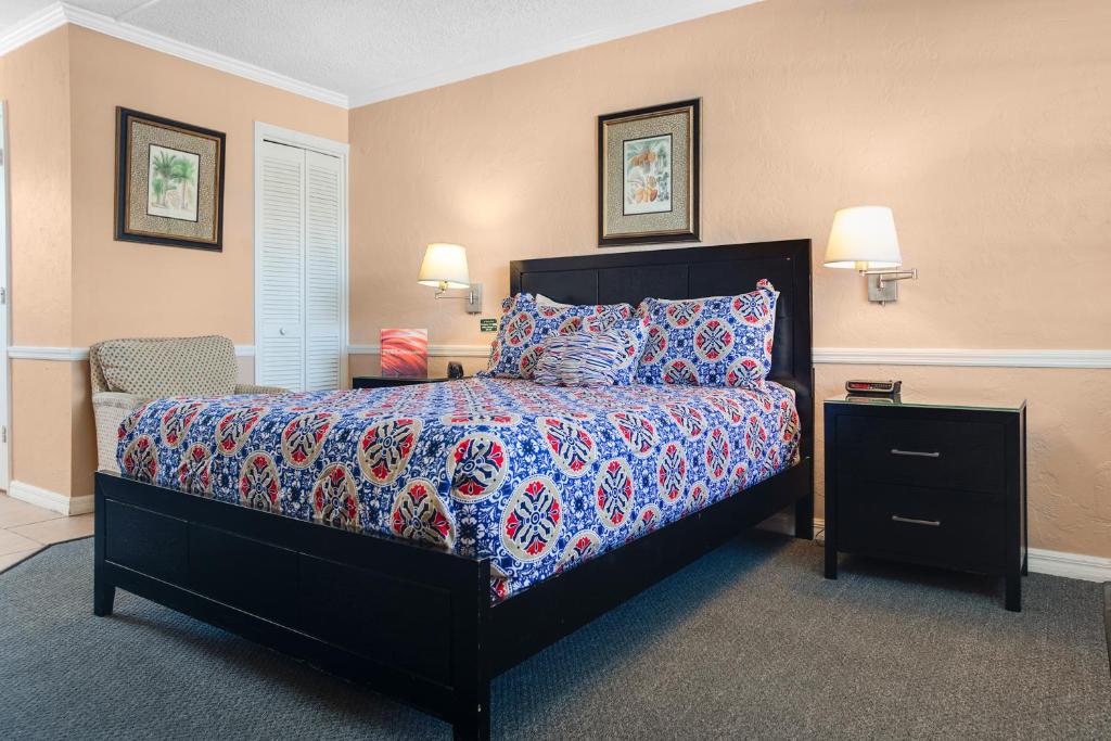 a bedroom with a large bed with a blue comforter at The BoatHouse in Marco Island