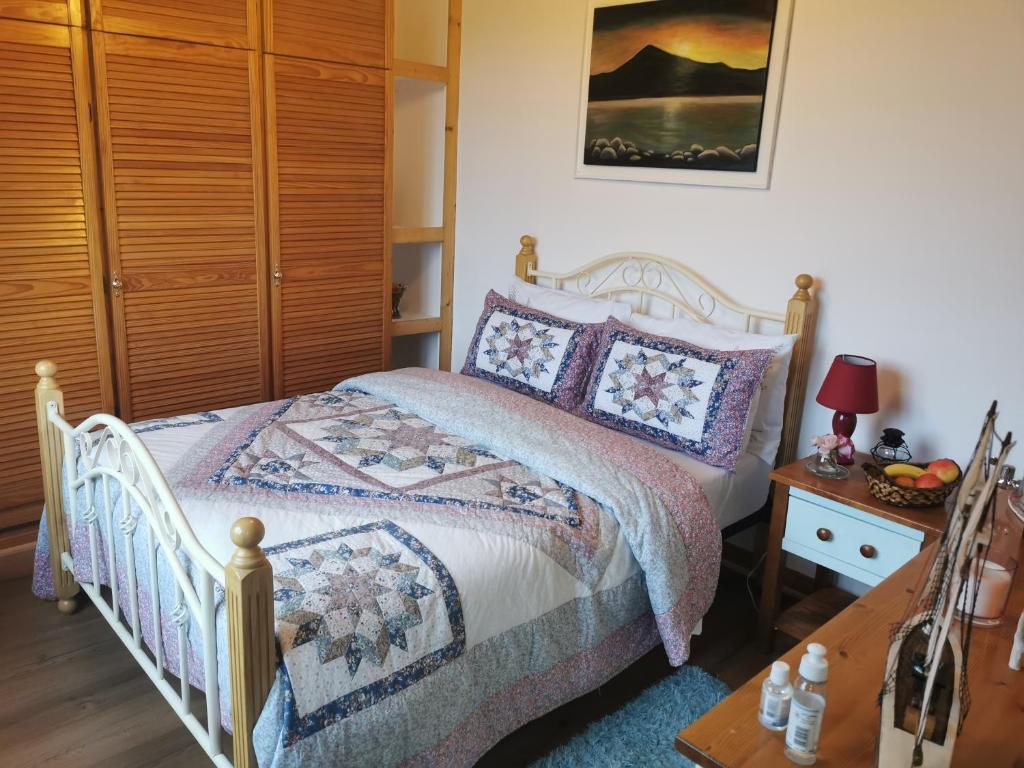 een slaapkamer met een bed en een houten kast bij Catherine's Lair A Quiet peaceful Homestay in Westport