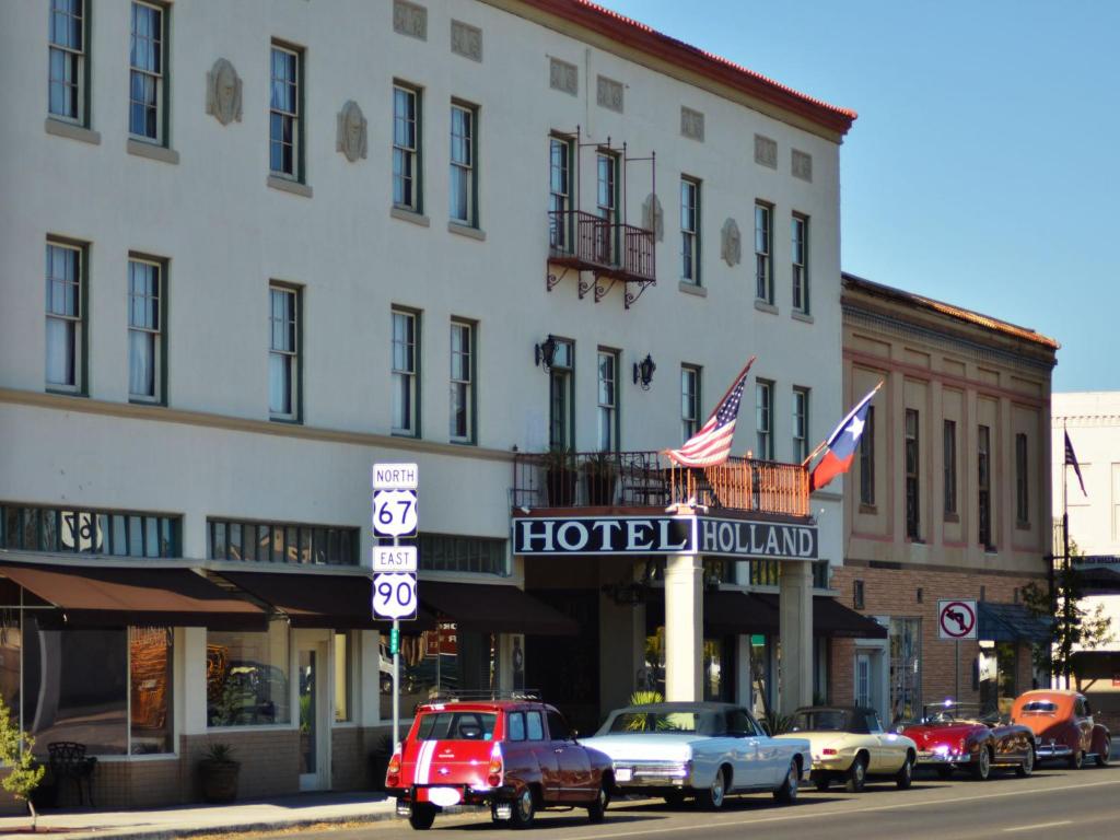 a street scene with cars parked in front of a building at The Holland Hotel in Alpine