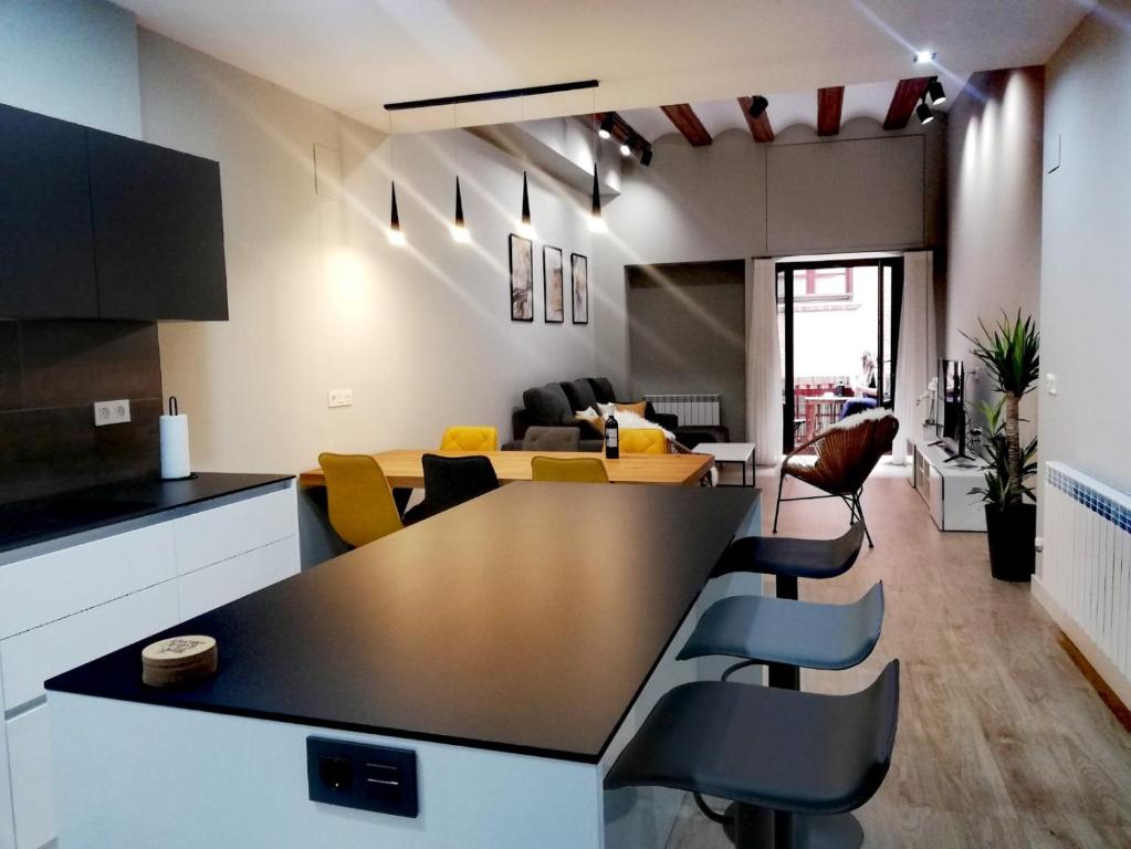 cocina y sala de estar con mesa y sillas en Palacete La Casa del Abuelo, en Tudela