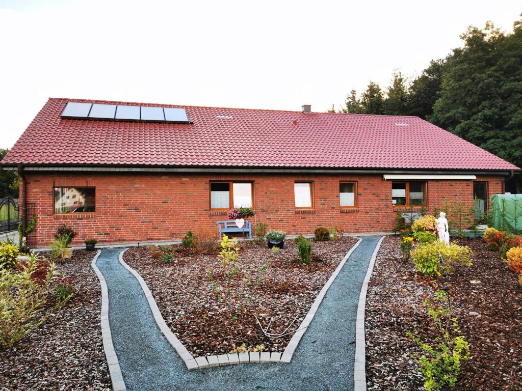 une maison en briques rouges avec un jardin en face de celle-ci dans l'établissement Ferienhaus/Ferienwohnung Fam. Manthey, à Harrendorf