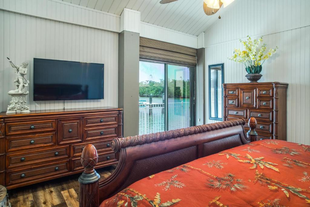 a bedroom with a flat screen tv and a bed at The BoatHouse in Marco Island