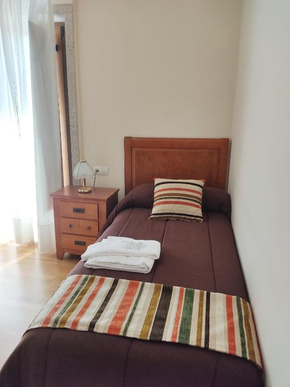 A bed or beds in a room at Pension a Fontiña