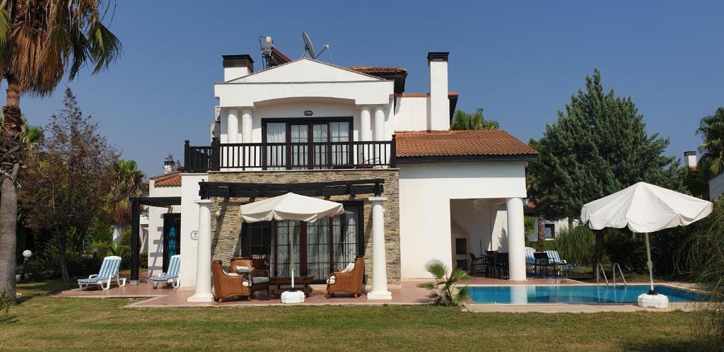 une maison avec une piscine en face de celle-ci dans l'établissement Antalya belek private villa private pool private beach 3 bedrooms close to land of legends, à Belek