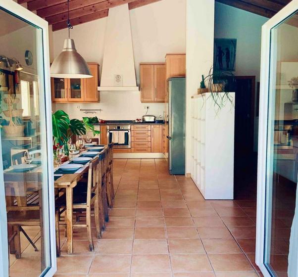 a kitchen with a table and a refrigerator at Endless Summer Surf House in Aljezur