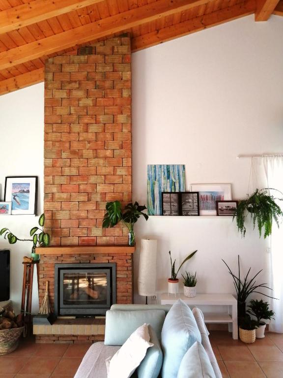a living room with a couch and a fireplace at Endless Summer Surf House in Aljezur
