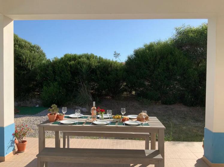 a picnic table with food and wine glasses on a patio at Endless Summer Surf House in Aljezur
