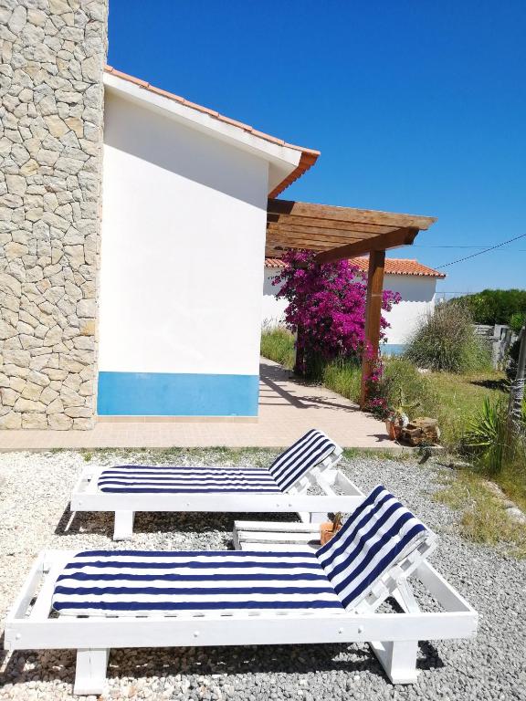 a couple of lounge chairs and a building at Endless Summer Surf House in Aljezur