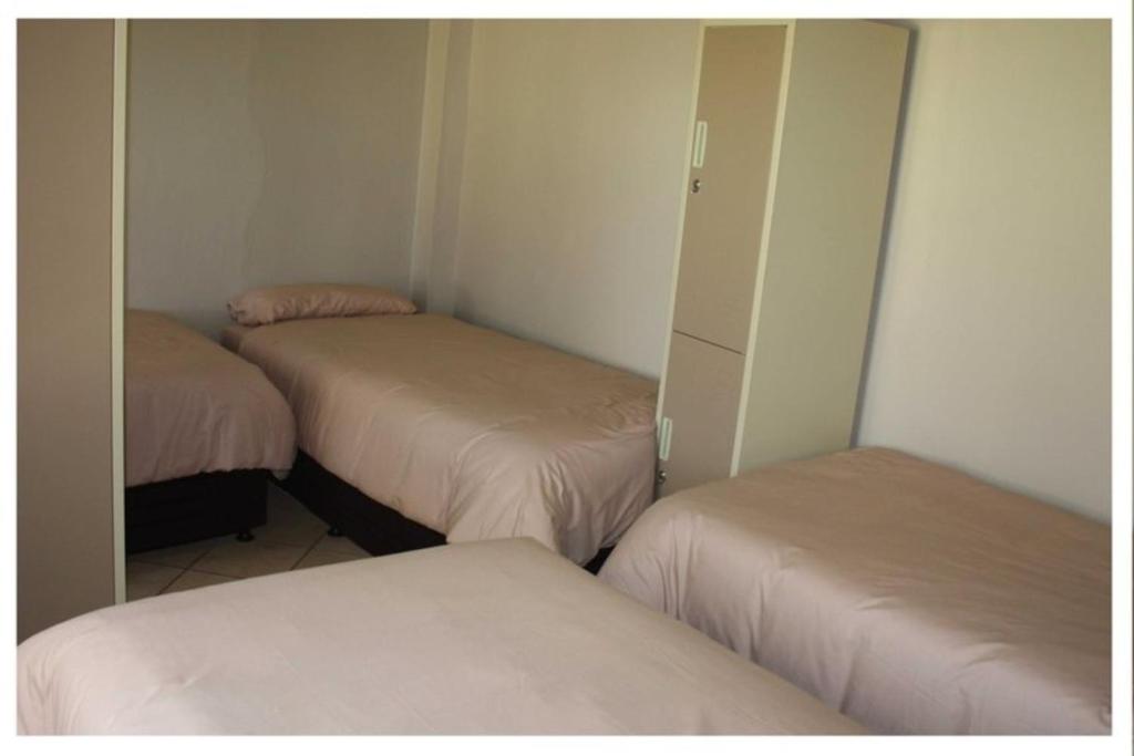 una camera con due letti e un armadio con specchi di Abuelita Guesthouse - Room 1 a Lephalale