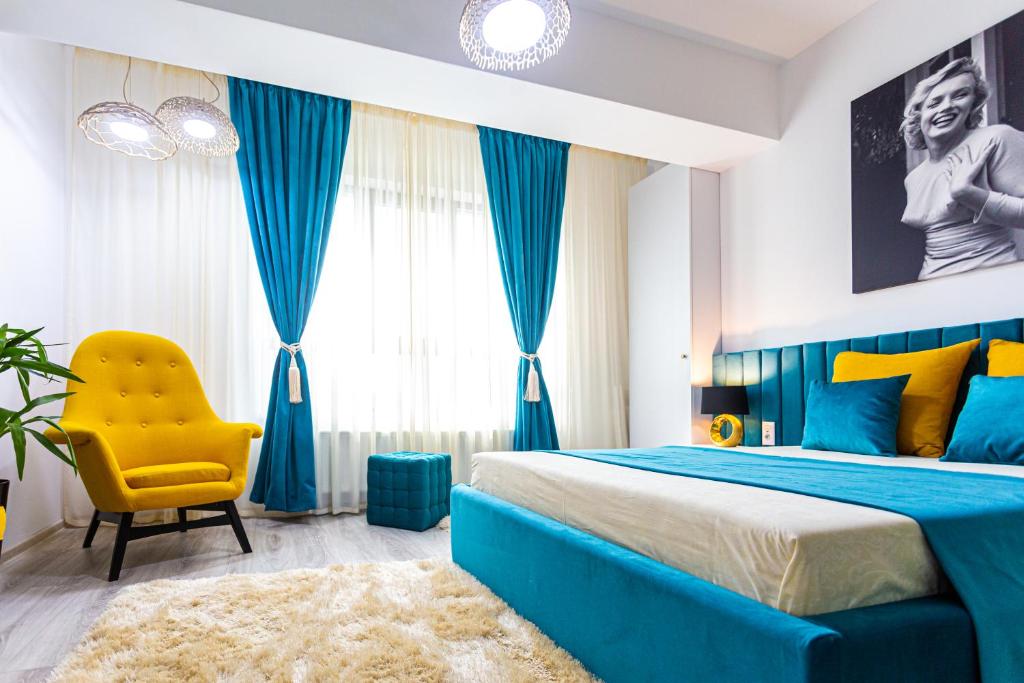 1 dormitorio con 1 cama azul y 1 silla amarilla en Unique Hotel Apartments Rond Vechi en Iaşi