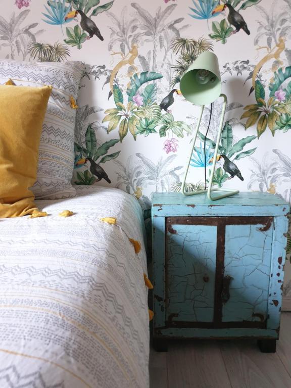 a bedroom with a bed and a nightstand with a lamp at Loft Design Typikindi in Douai