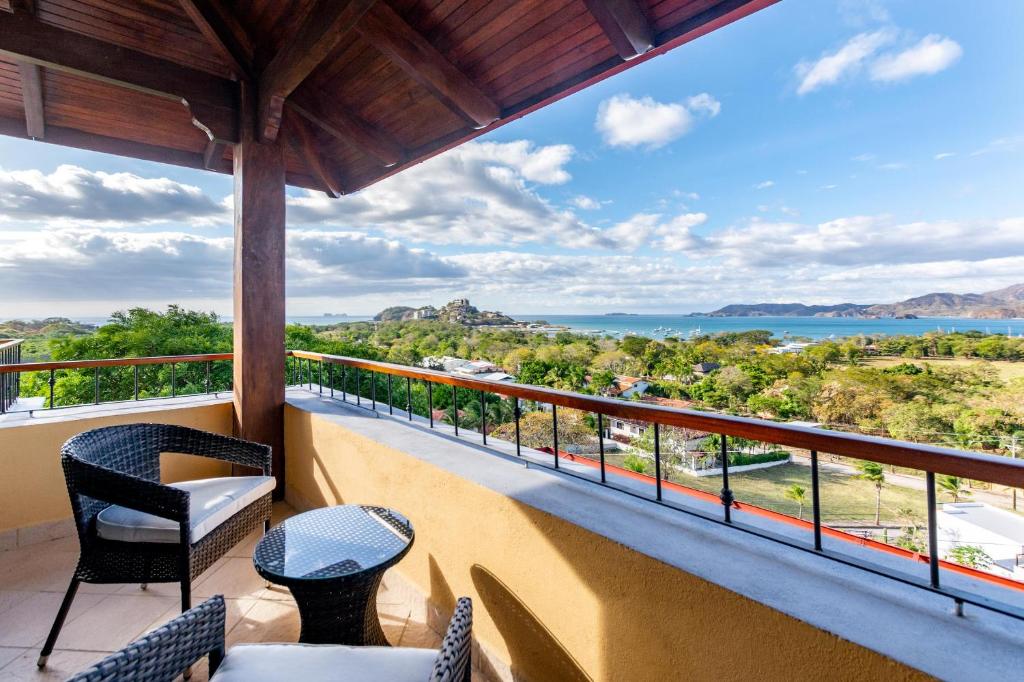 balcón con sillas y vistas al agua en Modern, Immaculate Unit in Flamingo with Spectacular Ocean Views, en Playa Flamingo