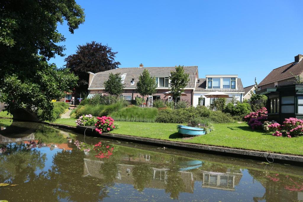 a house with a boat in the water at B&B - Pension Het Oude Dorp in Katwijk