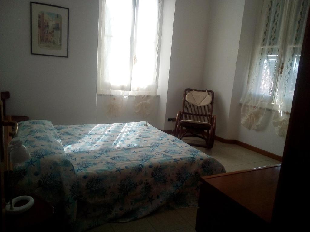 una camera con un letto e una sedia e una finestra di ANTICO BORGO AL MARE a Lavagna