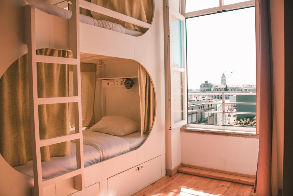 Ce lit superposé se trouve dans un dortoir doté d'une fenêtre. dans l'établissement Urban Garden Porto Central Hostel, à Porto