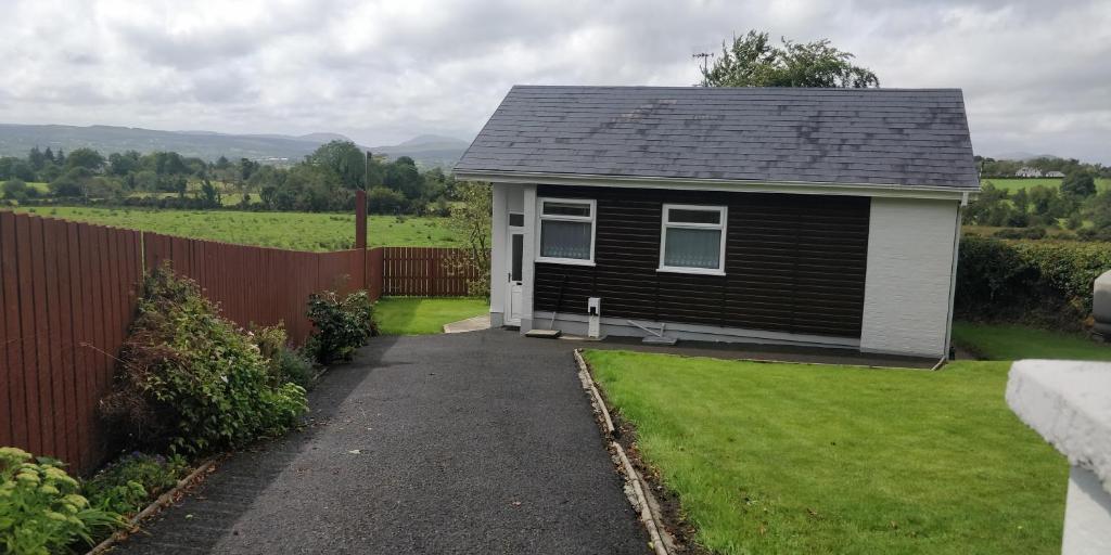 una pequeña casa con una valla al lado de un patio en The Bungalow Self-catering Accommodation en Ballybofey