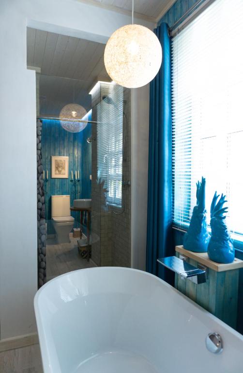 baño con bañera y ducha con paredes azules en Casa da Almoinha, en Unhais da Serra