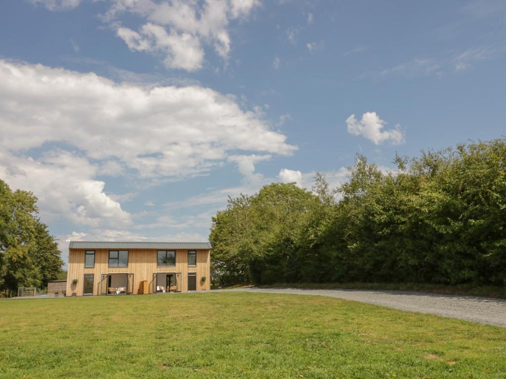 a building with a grass field in front of it at Monarch's Barn in Droitwich